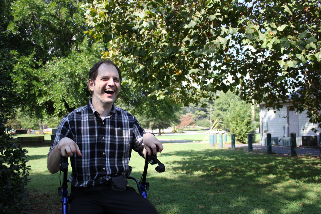 a person in a wheelchair laughing in the park