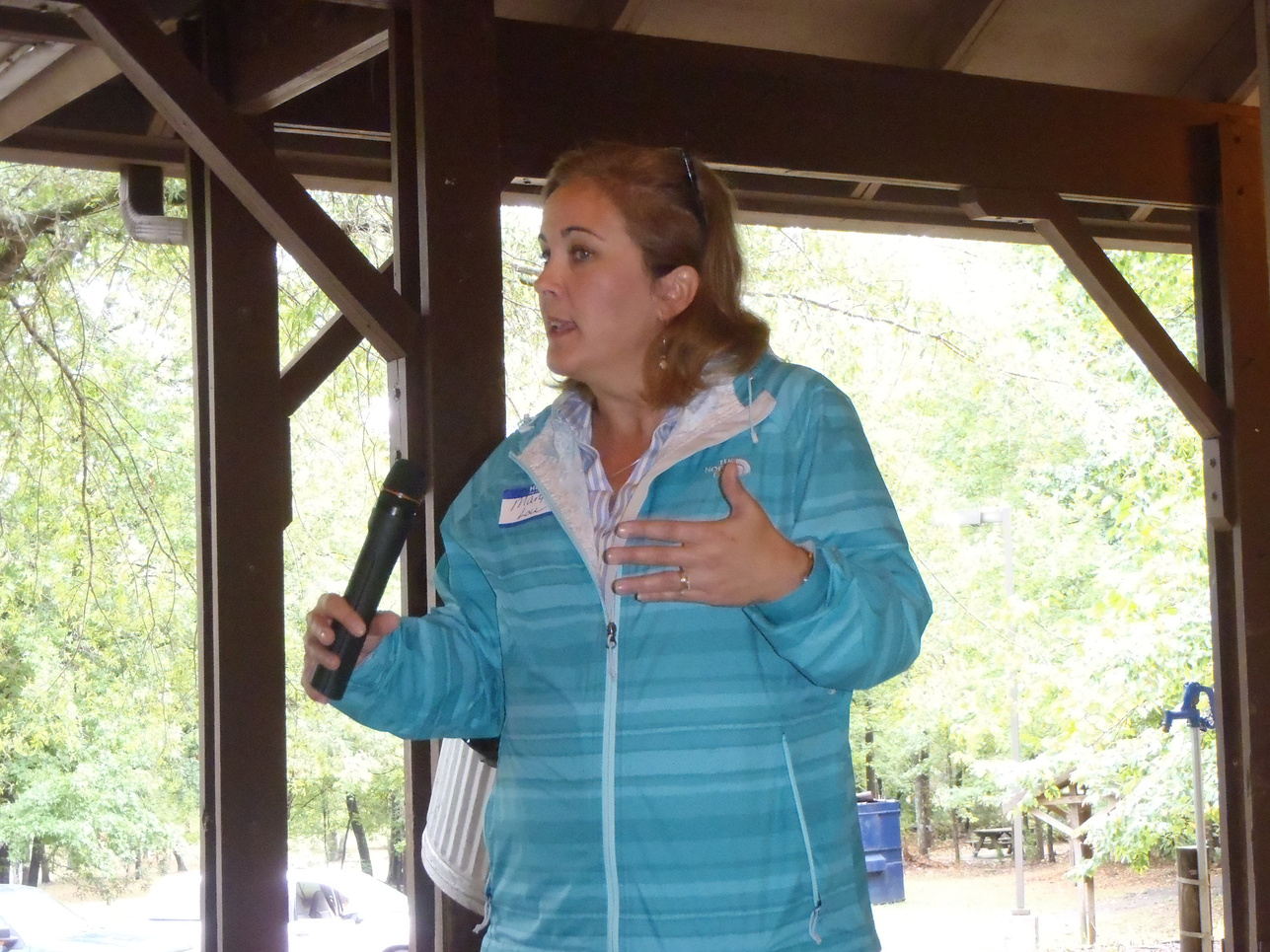 a person in a blue jacket speaking into a microphone.  